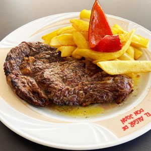 Entrecot de ternera gallega a la brasa con patatas fritas y pimiento rojo asado.