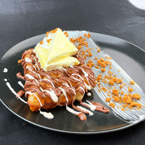 Gofre con chocolate, helado de vainilla, nata montada y virutas crujientes