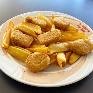 Plato de nuggets de pollo empanados con guarnición de patatas fritas.