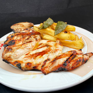 Pechuga de pollo a la brasa servida con guarnición de patatas fritas.