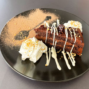 Tarta de chocolate con nata, virutas, cacao en polvo y chocolate blanco