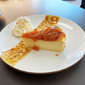 Tarta de queso con mermelada de níspero, nata montada y caramelo con almendra