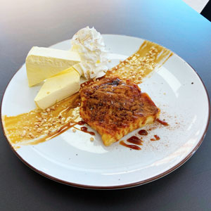 Torrija de pan brioche caramelizada con helado de vainilla y nata
