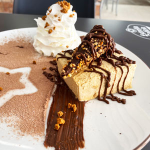 Volcán de turrón con chocolate fundido, nata montada y crujiente de cacahuete